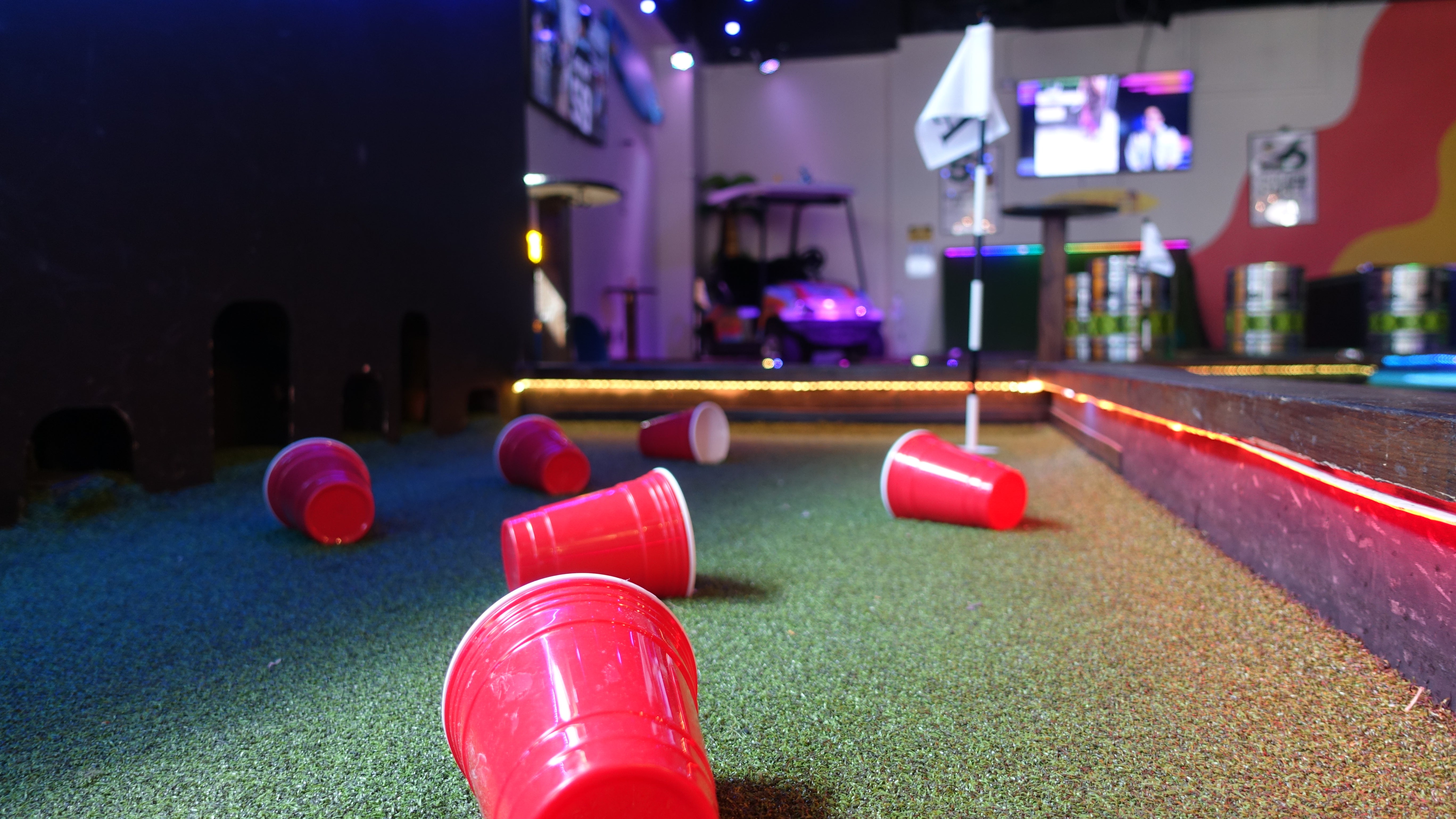 Friends playing indoor mini golf at Playground